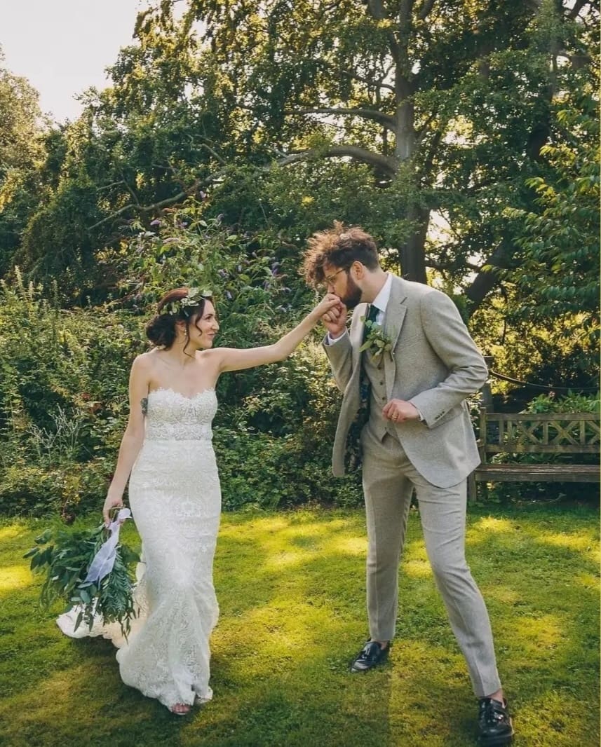 bride and groom walking through the gardens with greenery