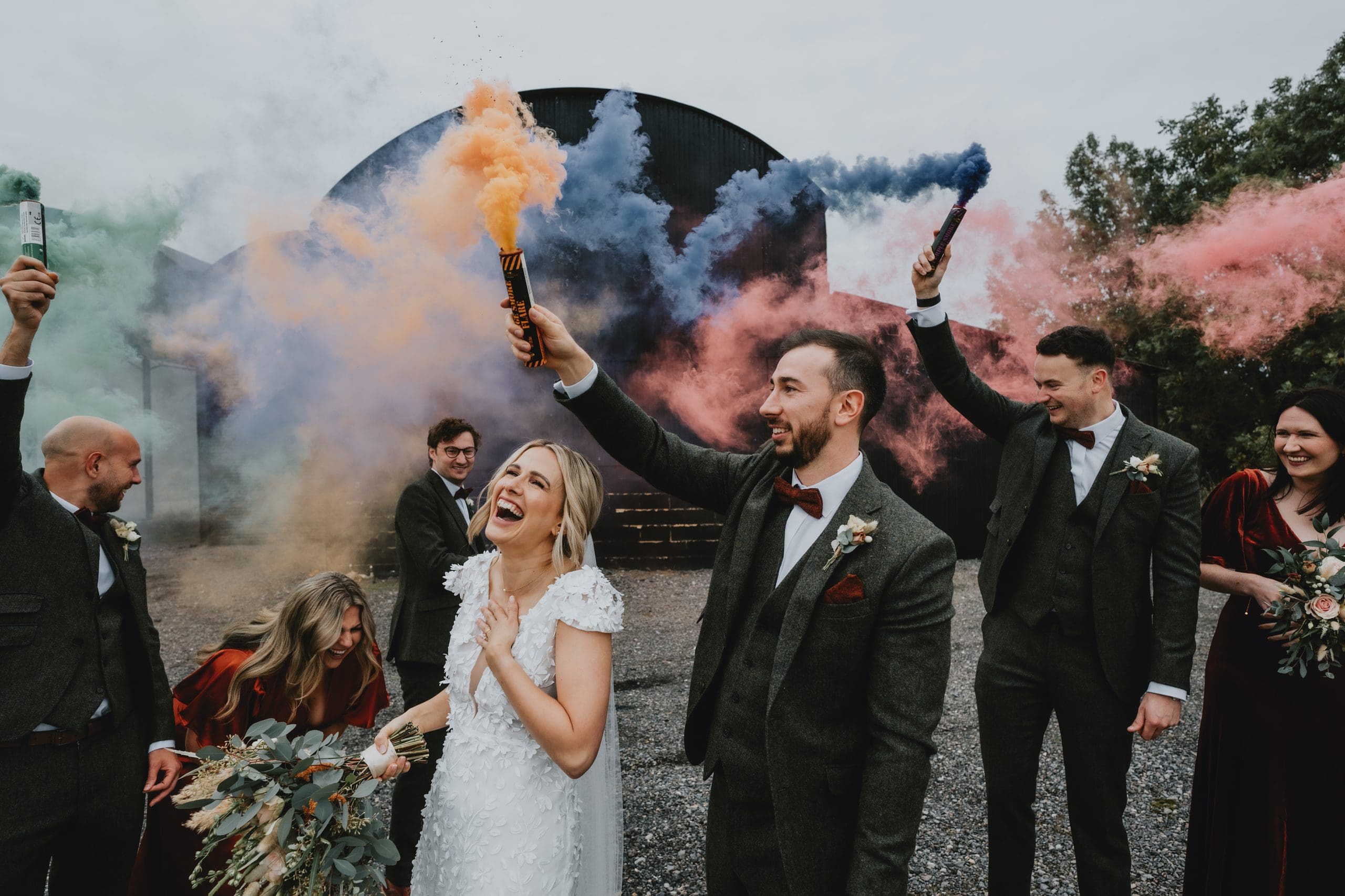 bride and groom laughing smoke bombs
